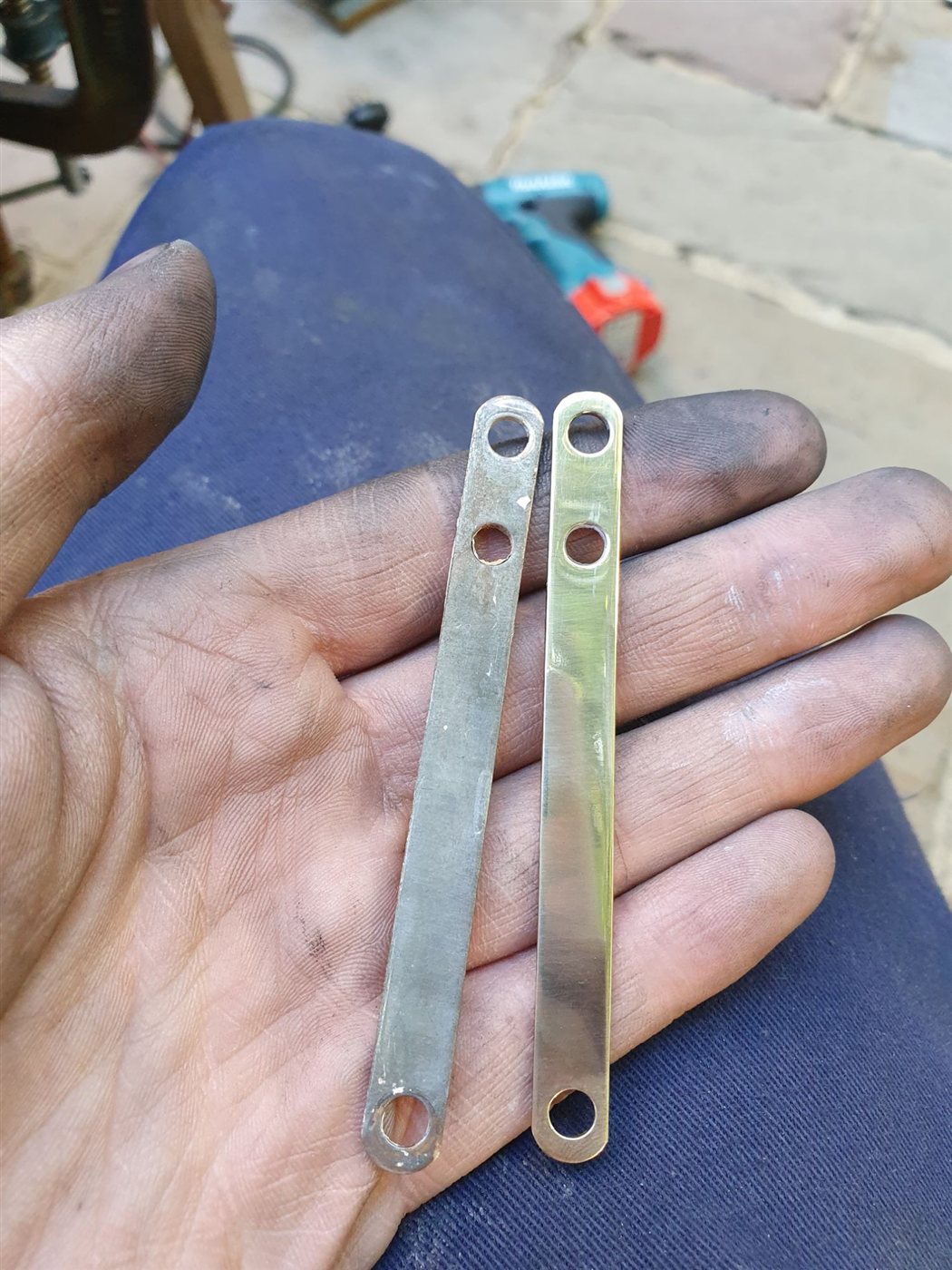 An untouched metal strip beside a finished one