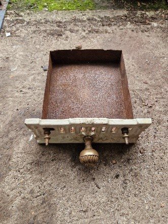 The ash tray with its brass front