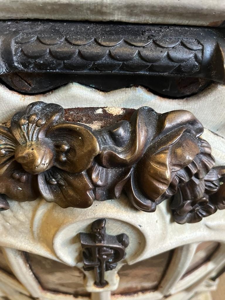 Darkened brass garland and crazed enamel above the door