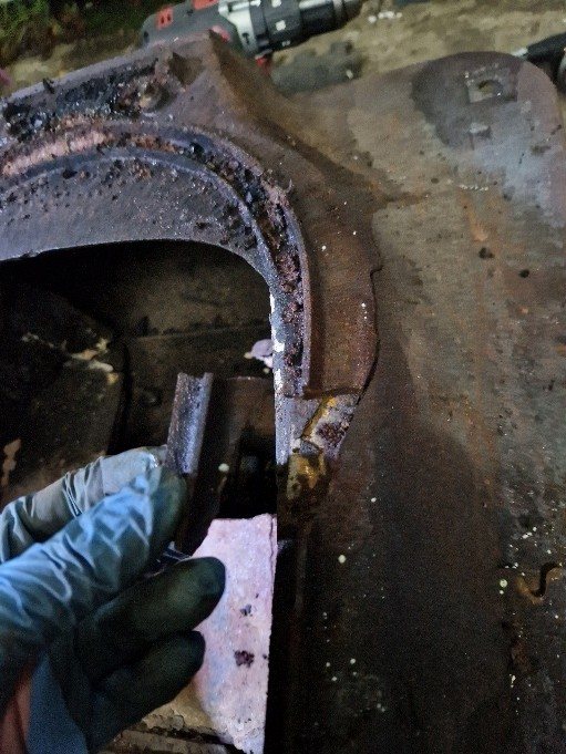 The crack and damaged section in the cast iron body