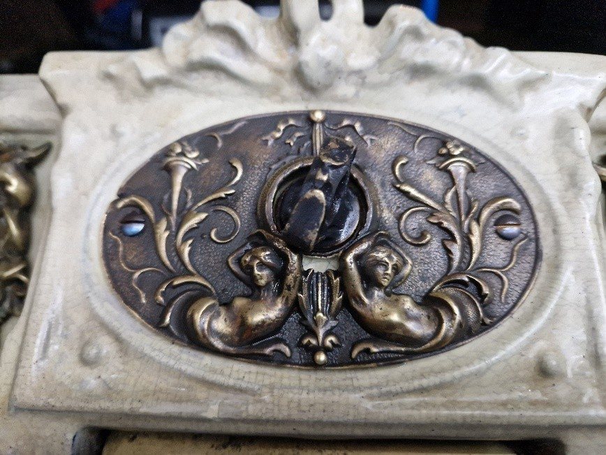 The restored brass escutcheon on the finished fireplace