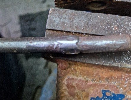 The snapped fire basket handle welded in a vice
