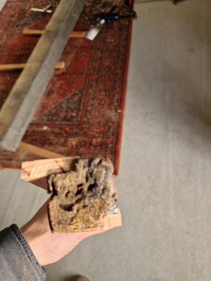A decayed corner block removed from the frame
